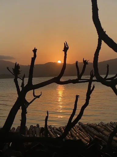Deck do Toca da Lontra ao pôr do sol sobre a Lagoa da Conceição, Florianópolis
